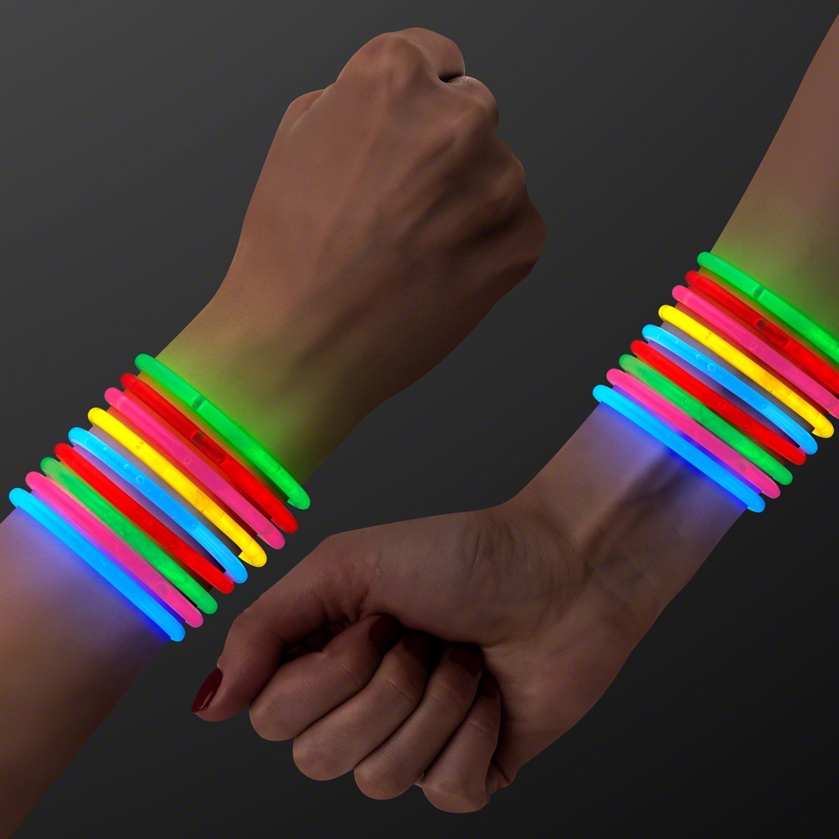 Two hands with several colorful 8 inch Glow Bracelets—green, red, yellow, blue, and orange—shine against a dark background. One hand forms a fist while the other is relaxed.