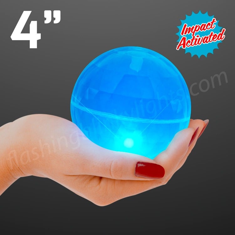 A hand with red nail polish holds a glowing 4" Super Sized Air Blue Bounce Ball with Flashing LEDs against a dark background—ideal as a fun party favor.