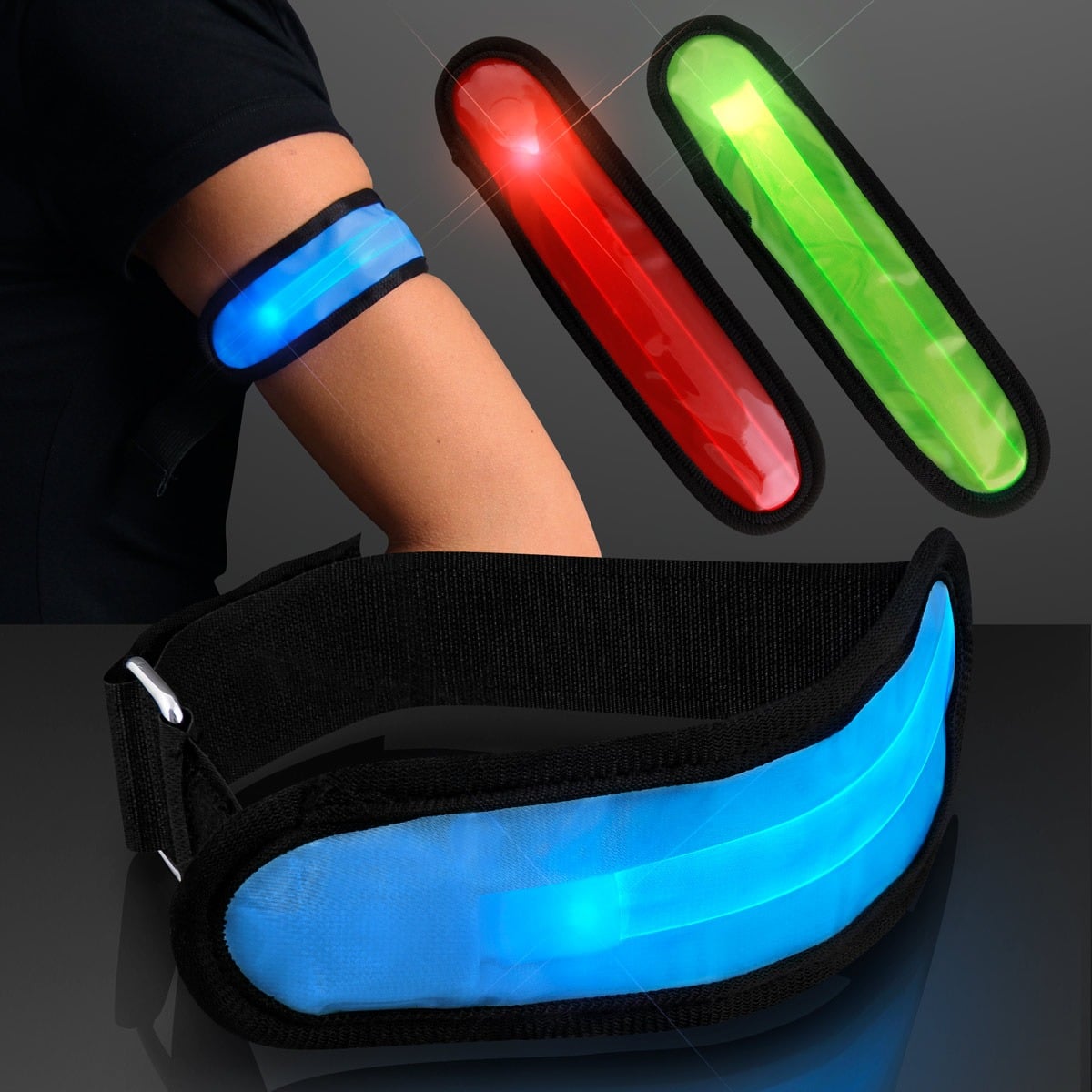 A person wears a blue LED Arm Band for Night Safety on their upper arm, with red and green versions also displayed nearby, plus a close-up of the glowing blue band against a dark background.