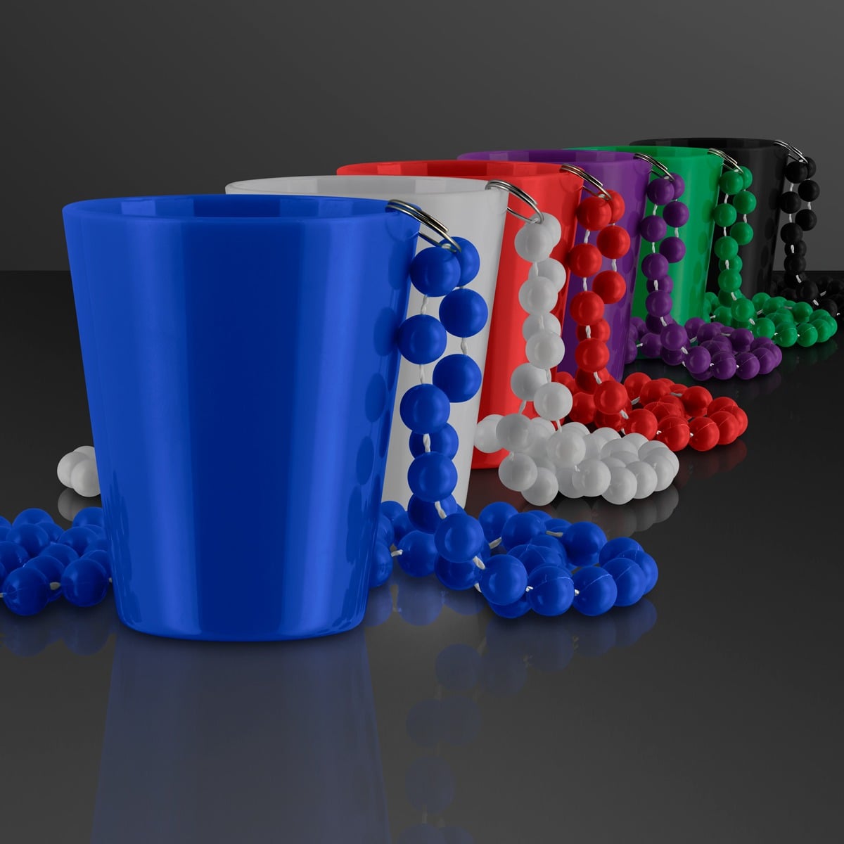 Six 1.5 oz. Shot Glass Bead Necklaces in blue, white, red, green, purple, and black are lined up diagonally with matching bead necklaces draped over each shot glass on a reflective black surface.