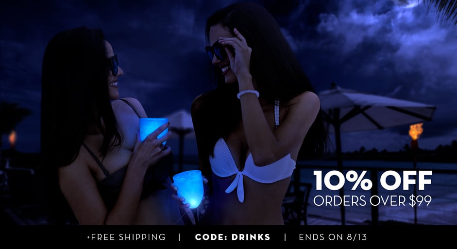 Two girls on the beach with their sunglasses on at night and light-up drinks in their hands. Nothing says 
